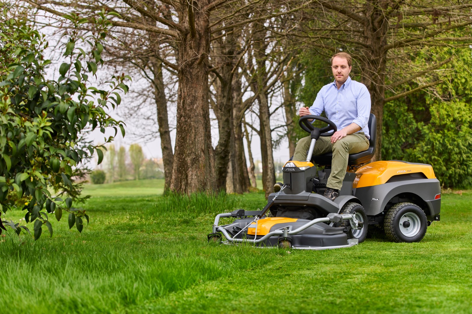 Man op een stiga front maaier aan het gras maaien
